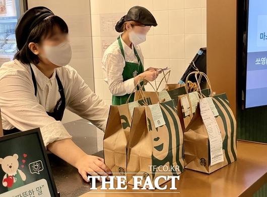 스타벅스 딜리버리 테스트 매장인 역삼이마트점은 이마트 역삼점 입구 왼편 고객센터가 있던 자리에 생겼다. 사진은 배달 주문 상품을 라이더에 전달하는 모습. /역삼=이민주 기자