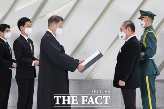 문재인 대통령이 1일 서울 서대문구 국립대한민국임시정부기념관에서 열린 제103주년 3·1절 기념식에서 고 이수준 씨를 대신해 손자 이건용 씨에게 건국훈장 애국장을 수여하고 있다. /뉴시스