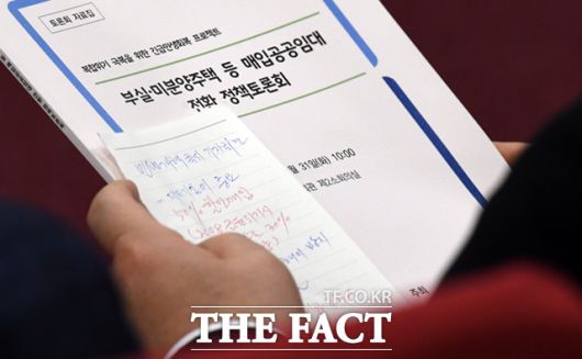 이재명 더불어민주당 대표가 31일 서울 여의도 국회 의원회관에서 열린 부실·미분양 주택 매입임대 전환 긴급토론회에 참석해 축사에 앞서 이용우 의원으로부터 받은 쪽지를 살펴보고 있다.