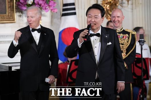 윤석열 대통령이 26일 저녁 (현지시간) 백악관에서 열린 국빈 만찬에서 조 바이든 대통령과 함께 무대에 올라 미국의 싱어송라이터 돈 맥클린의 '아메리칸 파이'를 부르고 있다. /뉴시스