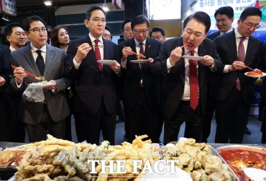 윤석열 대통령이 6일 부산 중구 깡통시장을 방문해 박형준 부산시장, 기업인들과 떡볶이를 시식하고 있다. 왼쪽부터 조현준 효성 그룹 회장, 이재용 삼성전자 회장, 박 시장, 윤 대통령, 구광모 LG그룹 회장. 윤 대통령은 "엑스포 유치했을 때보다 부산을 더 발전시키겠다"고 했다. /뉴시스