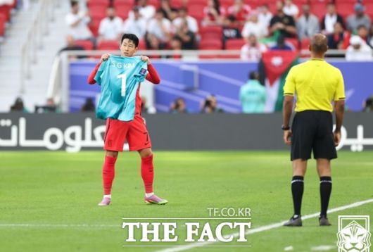 한국 축구의 '캡틴' 손흥민이 20일 요르단과 2023 아시안컵 E조 2차전에서 전반 9분 만에 페널티킥 선제골을 성공시킨 뒤 부상 아웃된 골키퍼의 김승규의 유니폼을 들고 세리머니를 펼치고 있다./도하=KFA