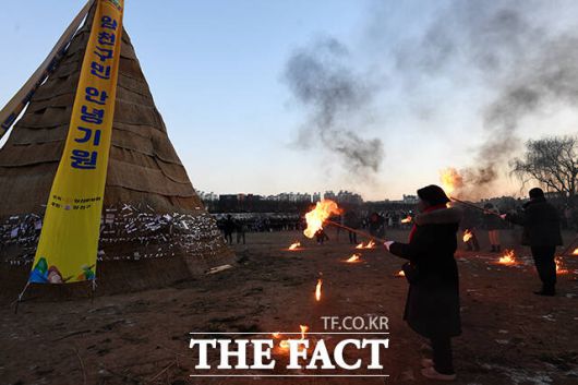 관계자들이 달집에 불을 붙이고 있다.