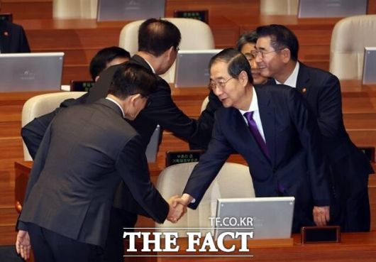 지난해 11월 한덕수 당시 국무총리(오른쪽)가 국회에서 김문수 당시 고용노동부 장관과 만나 악수하는 모습. 이들은 지난해 12월 3일 윤석열 전 대통령의 비상계엄 선포 당시에도 국무총리와 국무위원이었다. /뉴시스