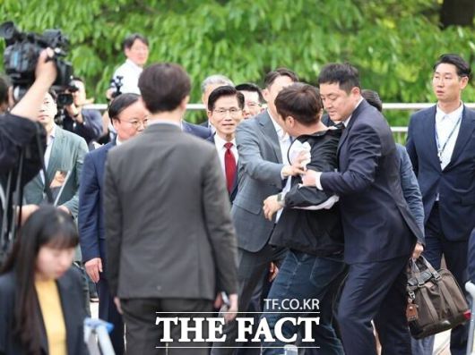 김문수 국민의힘 대선 후보가 지난 8일 한덕수 무소속 대선 후보와의 단일화 회동을 위해 나서던 중 한 남성으로부터 항의를 받고 있다. 이 남성은 "똑같은 내란 공범끼리 무슨 단일화입니까"라고 외쳤다. /뉴시스