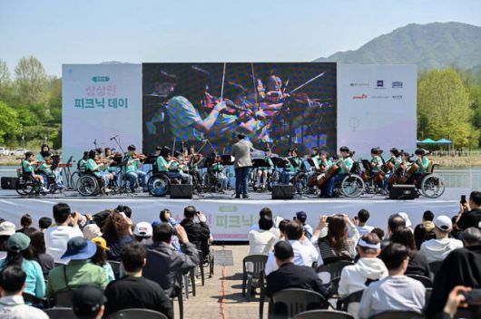 상상인그룹이 지난 4월 26일 경기도 하남 미사경정공원에서 개최한 '2025 피크닉데이'에서 상상휠(Wheel)하모니 오케스트라 단원들이 연주를 하고 있다. /상상인그룹