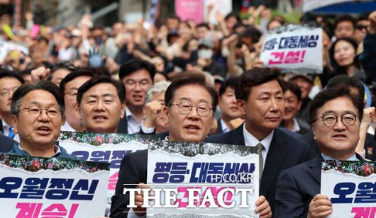 이재명 더불어민주당 대선 후보가 5·18민주화운동 45주기를 하루 앞둔 17일 오후 광주 동구 금남로에서 열린 5·18전야제에 참여해 손팻말을 든 모습. /뉴시스