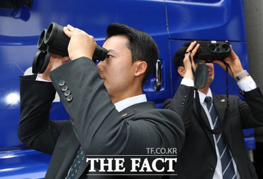 망원경으로 주변 살피는 경호 인력.