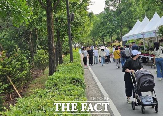 28일 오전 '2025 서울국제정원박람회'에 현대백화점이 크리스마스트리로 쓰인 전나무를 새롭게 심은 '더현대 포세스트' 공간 옆에서 시민들이 산책하고 있다. /동작구=우지수 기자