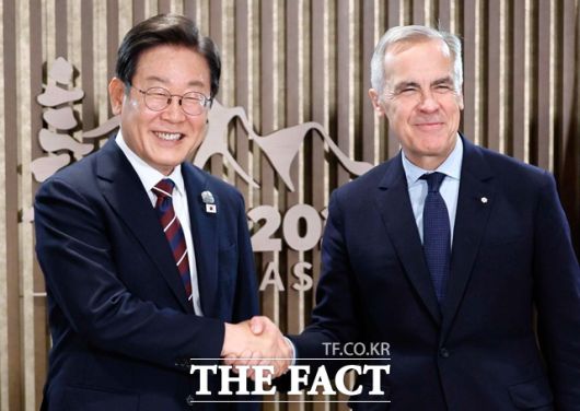 이재명 대통령이 17일(현지시간) 캐나다 앨버타주 카나나스키스 G7 정상회의장에서 열린 한-캐나다 정상회담에서 마크 카니 캐나다 총리와 악수하며 기념촬영을 하고 있다. /뉴시스