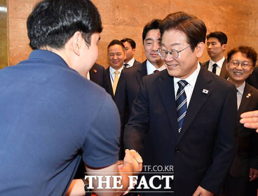 본회의장 나서며 국회 직원과 인사하는 이재명 대통령.