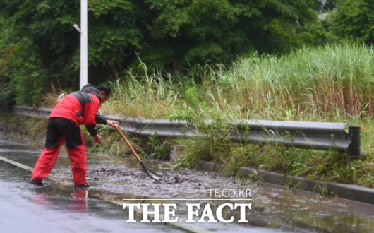 지난해 6월 경기 북부 지역에 호우경보가 내려진 가운데 경기도 파주시 문산읍 당동IC에서 파주시청 직원이 배수로에 막힌 진흙을 퍼내고 있다.