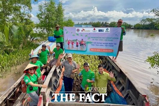 지난 5월 베트남 짜빈성 지역에서 맹그로브숲 복원사업 출범식을 마친 지역 관계자 및 주민들이 기념사진을 찍고 있다. /SK이노베이션