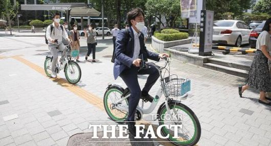 이 의원이 2021년 6월 서울의 한 호텔에서 열리는 포럼에 참석하기 위해 자전거를 타고 이동하는 모습. 이 의원은 당시 국민의힘 대표였다. /더팩트 DB