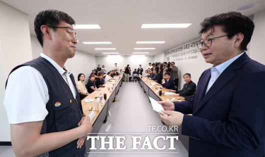 이한주(오른쪽) 국정기획위원장이 18일 서울 종로구 정부서울청사 창성동 별관 중회의실에서 열린 '지난 정부 노동정책 희생 유족 간담회에서 김정욱 금속노조 쌍용자동차지부 법규실장으로부터 이재명 대통령에게 보내는 편지를 전달 받고 있다. /뉴시스