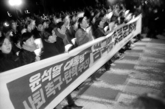 작품명은 'Lee Jae Myung - The first march (이재명-첫 시위 행진)'이다. 계엄 다음 날인 지난해 12월 4일, 이 사진을 찍을 당시에는 이재명 대통령(당시 더불어민주당 대표, 왼쪽 4번째)이 행진 중이라는 사실을 몰랐다고 한다. 사람이 너무 많아 인파 속으로 뛰어들어 사진을 찍었는데, 필름을 현상하고 인화를 하면서야 "어, 이 사람 알아!"라고 깨달았다고. /폴 개드 사진가 제공