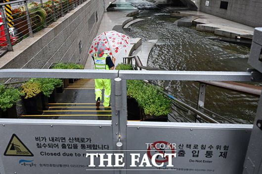 전국 대부분 지역에 많은 비가 내리고 있는 6일 오후 서울 종로구 청계천 산책로를 관계자가 통제하고 있다. /남용희 기자