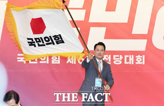 장동혁 국민의힘 신임 당 대표가 26일 서울 여의도 국회도서관에서 열린 국민의힘 제6차 전당대회 결선에서 선출된 뒤 당기를 흔들고 있다. /국회=배정한 기자