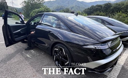 더 뉴 아이오닉6 운전석 도어가 열린 상태. 도어 패널은 손잡이 외에 버튼을 최소화해 단순하면서도 깔끔한 구성을 보여준다. 연장된 덕테일 스포일러와 픽셀 스타일 리어램프, 블랙 휠이 어우러져 후면부의 정제된 이미지를 강조한다. /황지향 기자