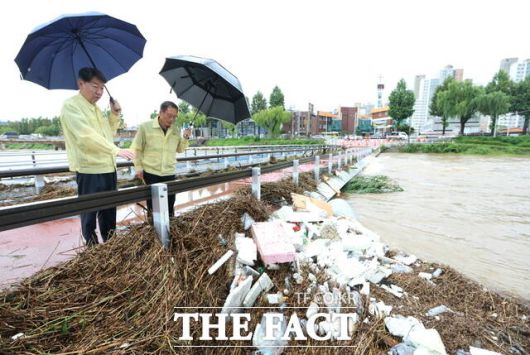 7일 오전 전북 전주시 완산구 태평동 전주천변 어은쌍다리에서 우범기 전주시장(왼쪽)이 관계 공무원과 함께 떠내려온 부유물과 각종 쓰레기 등으로 뒤엉켜 있는 하천을 보며 현장점검을 하고 있다. /전주시
