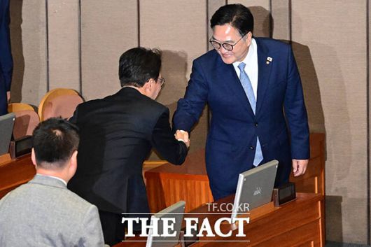 우원식 국회의장(오른쪽)이 본회의장에서 김민석 국무총리와 악수하고 있다.