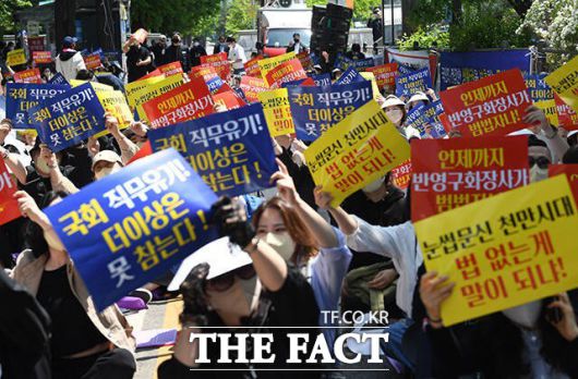 지난 2022년 제3차 문신사 법제화 범민족 촉구 집회가 3일 오후 서울 영등포구 국회의사당역 일대에서 열린 가운데 참가자들이 손피켓을 들어 보이고 있는 모습. / 남용희 기자