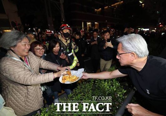 젠슨 황 CEO가 시민들에게 치킨과 감자튀김을 나눠주고 있다. /서예원 기자