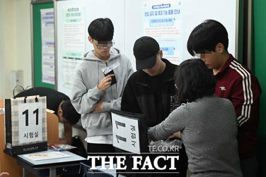 수험생들이 시험을 준비하며 전자기기를 보관함에 제출 하고 있다. /사진공동취재단