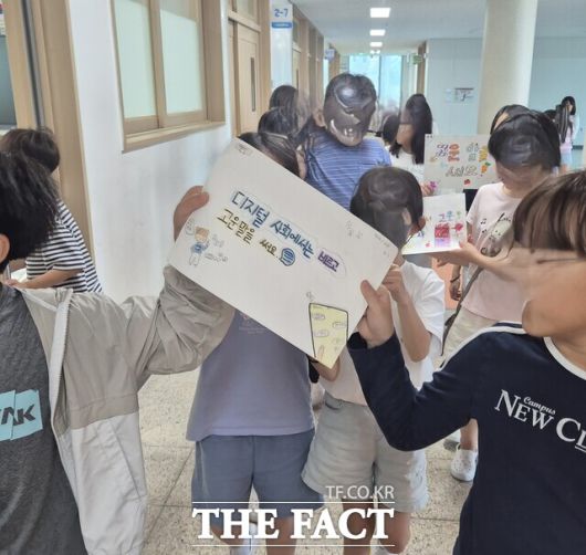 수청초 학생들이 채팅방에서 고운말 쓰기 운동 포스터를 만들어 복도에서 디지털 예절 캠페인을 펼치고 있다. /충남도교육청