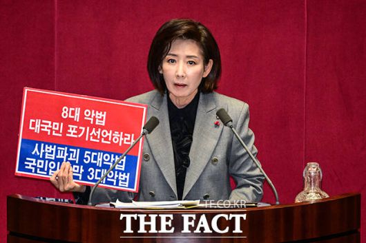 나경원 국민의힘 의원이 9일 오후 서울 여의도 국회에서 열린 본회의에서 '가맹사업거래의 공정화에 관한 법률 일부개정법률안'에 대한 무제한 토론에 나서며 '8대 악법 대국민 포기선언하라' 라고 적힌 손팻말을 들고 있다. /국회=남윤호 기자