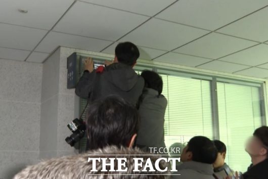 압수수색이 지연되는 가운데, 취재진들이 전재수 전 해양수산부 장관(현 더불어민주당 의원)의 국회 의원실 블라인드 틈 사이로 내부 상황을 살펴보고 있다. /국회=김민지 기자