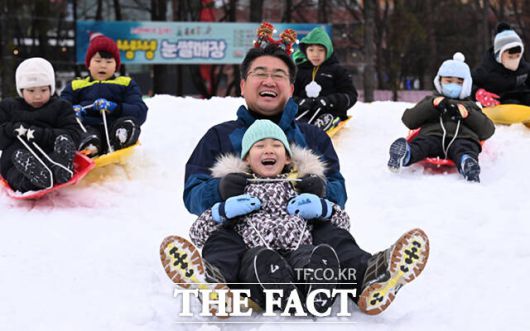 노원구가 23일 서울 노원구 서울과학기술대학교 종합운동장에서 '씽씽 눈썰매장'을 개장한 가운데, 오승록 구청장이 아이들과 눈썰매를 타고 있다.
