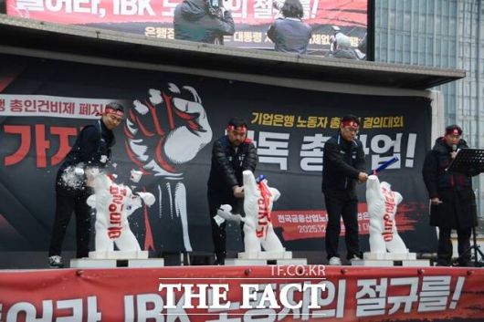 기업은행 노동조합원들이 ‘총인건비제’, ‘체불임금’, ‘차별임금’이 각각 적힌 석고상을 몽둥이로 부수는 퍼포먼스를 하고 있다. /김태환 기자