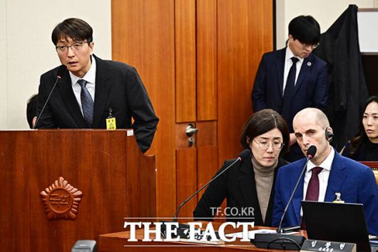 최민희 과방위원장의 경고를 받은 뒤 동시통역기 착용한 해롤드 로저스 쿠팡 대표이사. 왼쪽은 질의에 답변하는 박대준 쿠팡 전 대표.