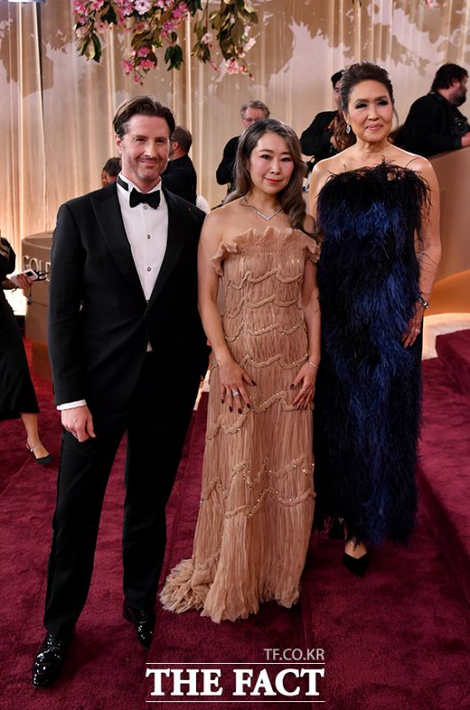 제83회 골든글로브 시상식 레드카펫 밟는 '케이팝 데몬 헌터스'의 매기 강 감독(가운데)과 크리스 아펠한스 감독(왼쪽), 미쉘 윙 제작자. /베벌리힐스=AP.뉴시스