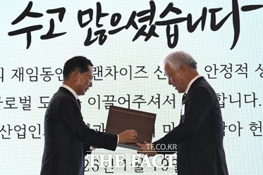나명석 신임 한국프랜차이즈산업협회장(왼쪽)이 정현식 전임 협회장에게 감사패를 전달하고 있다.