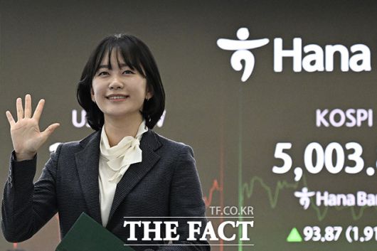 은행 관계자가 코스피 지수 5000을 손으로 표시하고 있다.