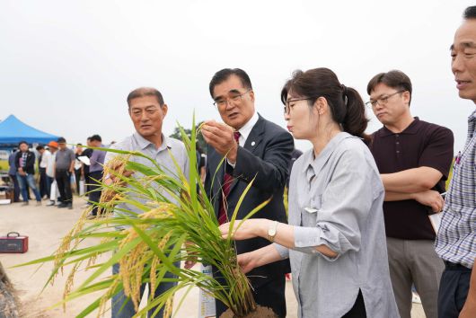 김기웅 군수가 벼 직파재배 평가회 참석하여 생산성에 대해 질문하고 있다(서천군)