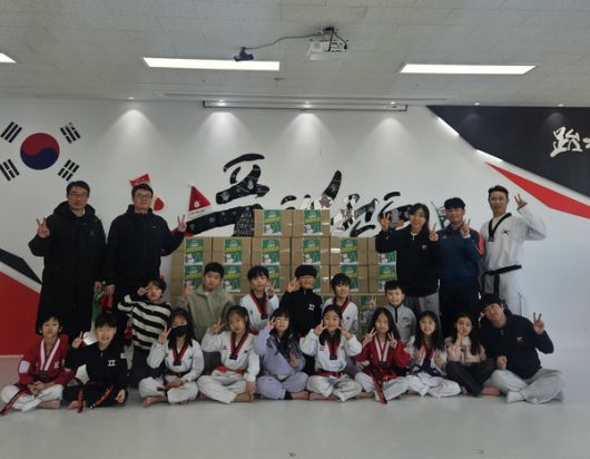 (사진/시흥시) 지난 26일 거북섬동 품태권도 학원생과 관계자들이 라면 900개를 후원하고 기념촬영을 하고 있다.