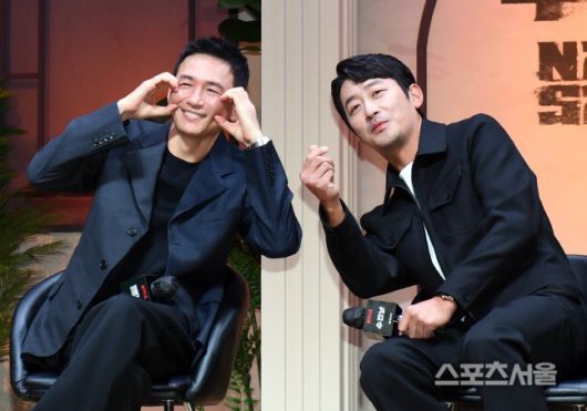 배우 황정민(왼쪽)과 하정우가 7일 오전 서울 강남구 조선팰리스 서울강남호텔에서 진행된 넷플릭스 시리즈 ‘수리남’ 제작발표회에서 취재진을 향해 포즈를 취하고 있다. ‘수리남’은 남미 국가 수리남을 장악한 무소불위의 마약 대부로 인해 누명을 쓴 한 민간인이 국정원의 비밀 임무를 수락하며 벌어지는 이야기를 그린 넷플릭스 시리즈로 배우 하정우, 황정민, 박해수, 조우진, 유연석이 출연하며 윤종빈 감독이 연출을 맡았다. 2022. 9. 7. 박진업기자 upandup@sportsseoul.com
