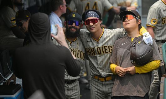 4-0으로 앞서가는 솔로 홈런을 터뜨린 2루수 김하성이 통역과 함께 덕아웃에서 샌디에이고만의 폴라로이드 기념사진에 응하고 있다. 피츠버그|AFP연합뉴스