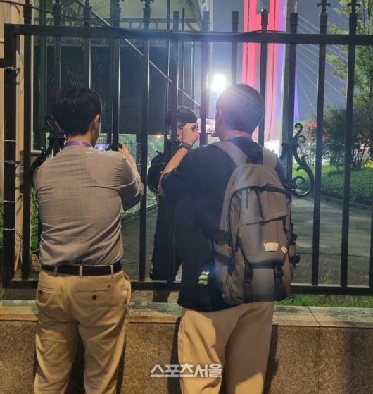 철장을 사이에 두고 황재원과 인터뷰하는 취재진.