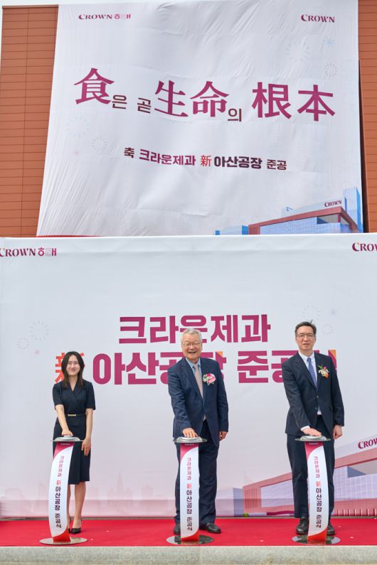 크라운제과 新아산공장 준공을 기념해 윤영달 크라운해태제과 회장(가운데)과 윤석빈 크라운제과 대표이사(오른쪽), 신입사원 손유리 사원(왼쪽)이 제막식 행사를 하고 있다. 사진 | 연합뉴스