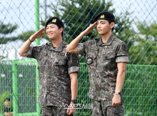 방탄소년단(BTS)의 RM(왼쪽, 김남준)과 뷔(김태형)가 10일 강원도 춘천시 신북읍 체육공원에서 진행된 전역 행사에서 팬과 취재진을 향해 거수 경례를 하고 있다.RM은 육군 제15보병사단 군악대에서, 뷔는 2군단 군사경찰 특수임무대에서 1년 6개월 동안 군복무를 했다. 2025. 6. 10. 춘천 | 박진업 기자 upandup@sportsseoul.com