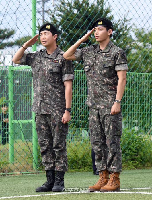 방탄소년단(BTS)의 RM(왼쪽, 김남준)과 뷔(김태형)가 10일 강원도 춘천시 신북읍 체육공원에서 진행된 전역 행사에서 팬과 취재진을 향해 거수 경례를 하고 있다.RM은 육군 제15보병사단 군악대에서, 뷔는 2군단 군사경찰 특수임무대에서 1년 6개월 동안 군복무를 했다. 2025. 6. 10. 춘천 | 박진업 기자 upandup@sportsseoul.com