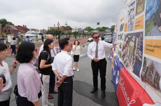 육동한 춘천시장이 18일(현지시간) 개빈 버클리 아나폴리스 시장과 함께 ‘A New City Dock Park is Coming’ 안내문이 설치된 도시재생 현장을 둘러보며 수변공간 재생 프로젝트에 대한 설명을 듣고 있다. 양 도시는 이날 도시 간 우호 협력 의향서(LOI)에 서명했다.  사진|춘천시청