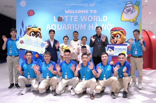 누적 관람객 100만 명 달성을 기념해 손님과 함께 기념 촬영 중인 이해열 롯데월드 베트남 법인장(두 번째 줄 왼쪽에서 세 번째)과 직원들의 모습. 사진 | 롯데월드