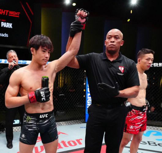 심판이 타츠로의 손을 들며 승리를 선언하고 있다. 오른쪽의 박현성이 시무룩한 표정을 짓고 있다. 사진 | UFC