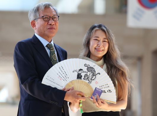 넷플릭스 애니메이션 ‘케이팝 데몬 헌터스’의 매기 강 감독(오른쪽)이 국립중앙박물관을 방문해 유홍준 관장으로부터 부채와 까치·호랑이 배지 선물을 받은 뒤 기념촬영을 하고 있다. 사진 | 연합뉴스