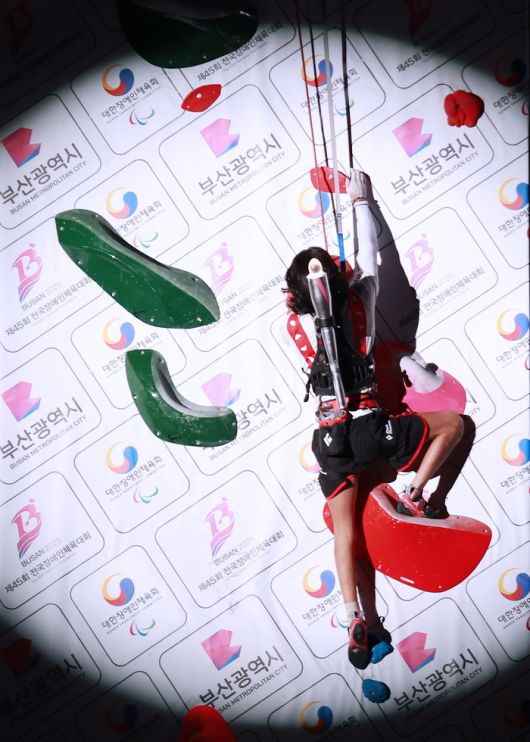 31일 부산아시아드주경기장 열린 제45회 전국장애인체육대회 개회식에서 파라클라이밍 종목 윤태인이 성화대를 등반하고 있다. 사진 | 대한장애인체육회